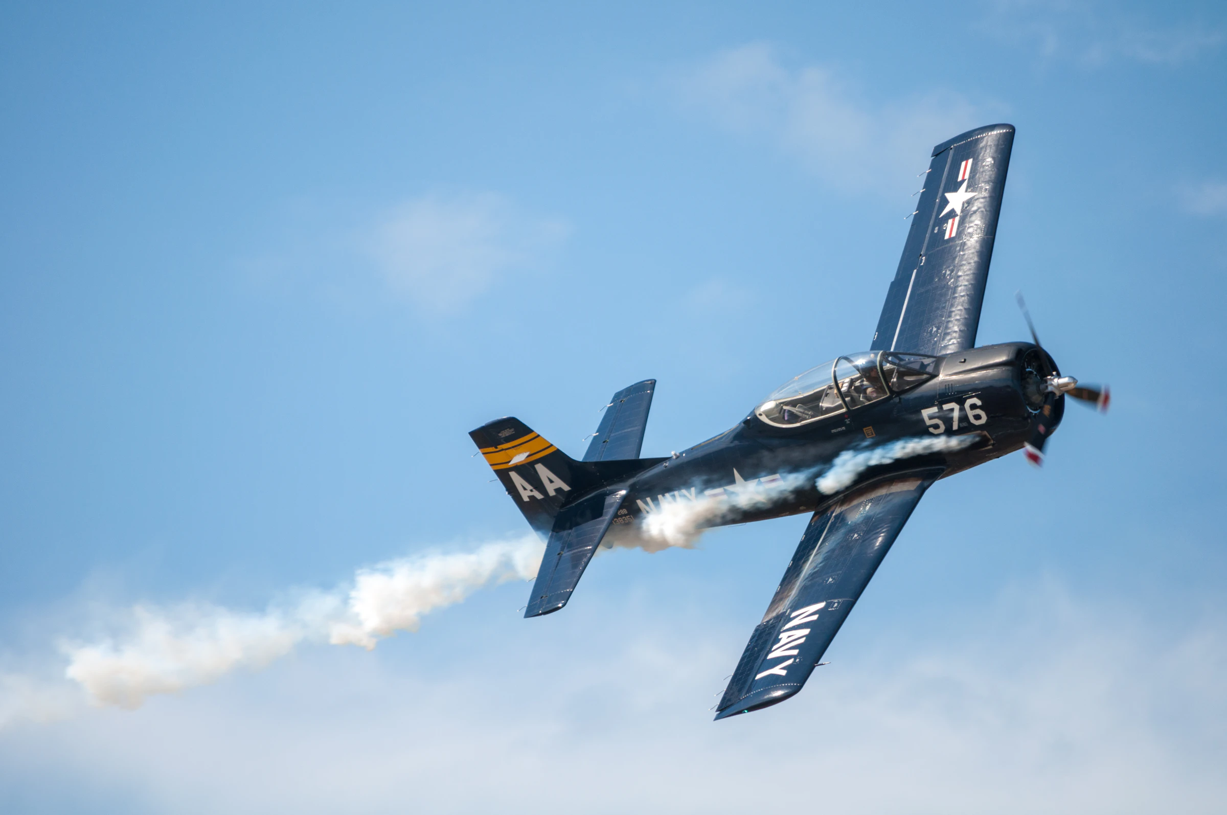 A restored biplane banking through open sky.